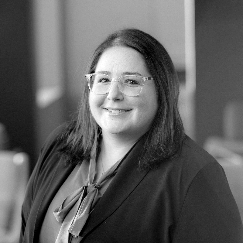 A black and white portrait of Stacey Katz smiling to the camera